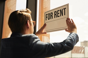 man putting up for rent sign